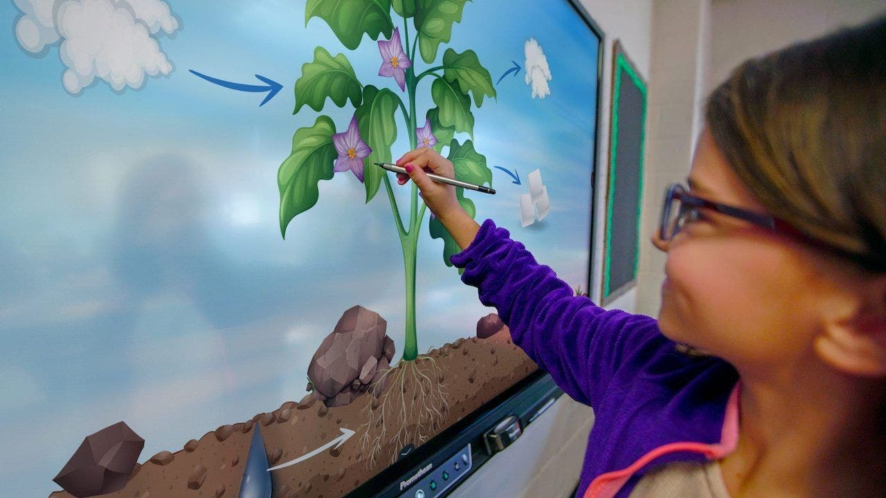 teacher with young students working on an interactive display in the classroom